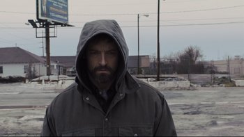 Movie still from “Prisoners” (2013), directed by Denis Villeneuve – A man with a beard wearing a hooded jacket; Close Up shot, Low angle