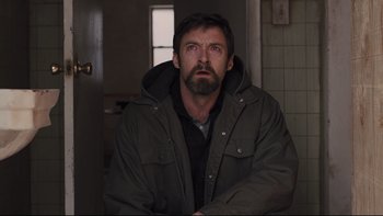 Movie still from “Prisoners” (2013), directed by Denis Villeneuve – A man with a beard wearing a jacket; Medium shot, Low angle