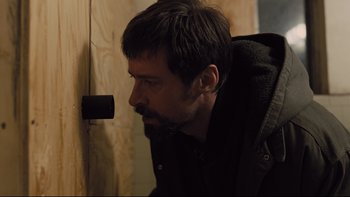 Movie still from “Prisoners” (2013), directed by Denis Villeneuve – A man with a goatee leaning up against a wall; Close Up shot, Low angle
