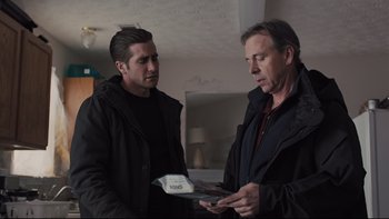 Movie still from “Prisoners” (2013), directed by Denis Villeneuve – Two men are talking in a living room together; Medium shot, Over the shoulder angle
