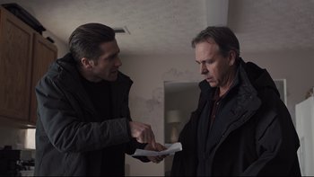Movie still from “Prisoners” (2013), directed by Denis Villeneuve – Two men are holding papers in their hands; Medium shot, Over the shoulder angle