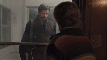 Movie still from “Prisoners” (2013), directed by Denis Villeneuve – A man looking in a mirror while a woman looks on; Medium shot, Over the shoulder angle