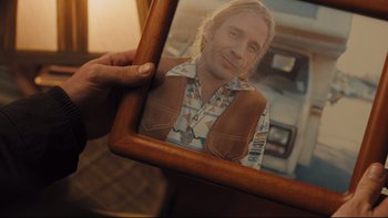 Movie still from “Prisoners” (2013), directed by Denis Villeneuve – A person holding a picture of a man in a brown vest; Close Up shot, Over the shoulder angle