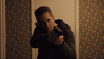 Movie still from “Prisoners” (2013), directed by Denis Villeneuve – A man holding a gun while wearing a black jacket; Close Up shot, Low angle
