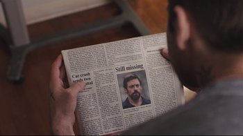 Movie still from “Prisoners” (2013), directed by Denis Villeneuve – A man reading a newspaper with a picture of a man missing; Close Up shot, Over the shoulder angle