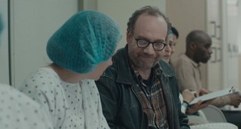 Movie still from “Private Life” (2018), directed by Tamara Jenkins – A man and a woman sitting next to each other in a room; Close Up shot, Over the shoulder angle
