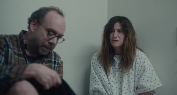 Movie still from “Private Life” (2018), directed by Tamara Jenkins – A man and a woman sitting next to each other in front of a white wall; Medium shot, Over the shoulder angle