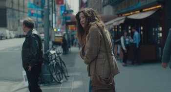 Movie still from “Private Life” (2018), directed by Tamara Jenkins – A woman is talking on her cell phone on the sidewalk; Medium shot, Over the shoulder angle