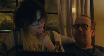 Movie still from “Private Life” (2018), directed by Tamara Jenkins – A woman wearing glasses is looking at a computer screen; Medium shot, Over the shoulder angle