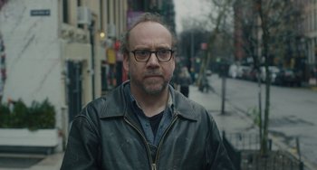 Movie still from “Private Life” (2018), directed by Tamara Jenkins – A man with a beard and glasses standing on the sidewalk; Close Up shot, Over the shoulder angle