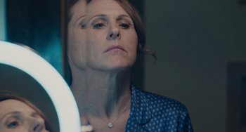 Movie still from “Private Life” (2018), directed by Tamara Jenkins – A woman looking in the mirror in front of a bathroom mirror; Close Up shot, Over the shoulder angle
