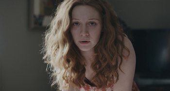 Movie still from “Private Life” (2018), directed by Tamara Jenkins – A woman with long red curly hair stares at the camera; Close Up shot, Low angle