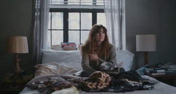 Movie still from “Private Life” (2018), directed by Tamara Jenkins – A woman sitting on a bed in front of a window; Medium shot, High angle