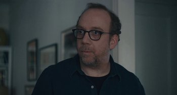 Movie still from “Private Life” (2018), directed by Tamara Jenkins – A person wearing glasses and a black shirt; Close Up shot, Over the shoulder angle