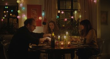 Movie still from “Private Life” (2018), directed by Tamara Jenkins – Three people sitting at a dinner table with lit candles; Medium shot, High angle