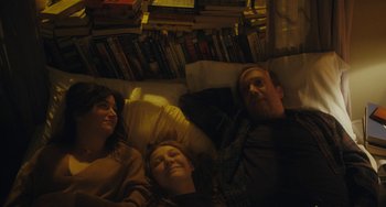 Movie still from “Private Life” (2018), directed by Tamara Jenkins – Three people laying on a bed in a room; Medium shot, High angle