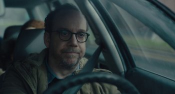 Movie still from “Private Life” (2018), directed by Tamara Jenkins – A man with glasses sitting in the driver's seat of a car; Close Up shot, Over the shoulder angle