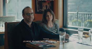 Movie still from “Private Life” (2018), directed by Tamara Jenkins – A man and a woman sitting at a wooden table; Medium shot, High angle