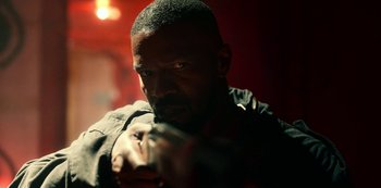 Movie still from “Project Power” (2020), directed by Henry Joost – A man with a gun in his hand; Close Up shot, Over the shoulder angle