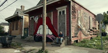 Movie still from “Project Power” (2020), directed by Henry Joost – A man sitting on the steps outside of a building; Extreme Wide shot, Low angle