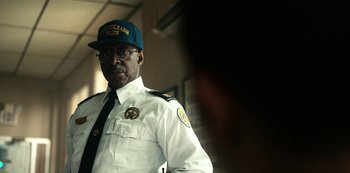 Movie still from “Project Power” (2020), directed by Henry Joost – A man in a white uniform and a blue hat; Close Up shot, Over the shoulder angle