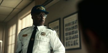 Movie still from “Project Power” (2020), directed by Henry Joost – A man in a white uniform and a blue hat; Close Up shot, Over the shoulder angle