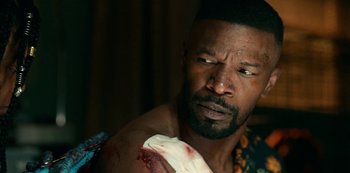 Movie still from “Project Power” (2020), directed by Henry Joost – A person with a wound on his arm; Close Up shot, Over the shoulder angle