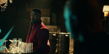 Movie still from “Project Power” (2020), directed by Henry Joost – A man sitting at a table with a drink in front of him; Medium shot, Over the shoulder angle