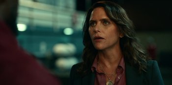 Movie still from “Project Power” (2020), directed by Henry Joost – A person with long hair wearing a suit; Close Up shot, Over the shoulder angle