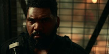 Movie still from “Project Power” (2020), directed by Henry Joost – A person with a beard looking at the camera; Close Up shot, Over the shoulder angle