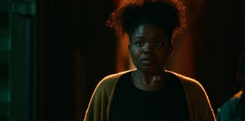 Movie still from “Project Power” (2020), directed by Henry Joost – A woman with a black shirt and a yellow sweater; Close Up shot, Over the shoulder angle