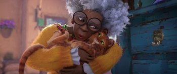 Movie still from “Puss in Boots: The Last Wish” (2022), directed by Januel Mercado – An old woman holding an orange cat with a white wig; Close Up shot, Over the shoulder angle