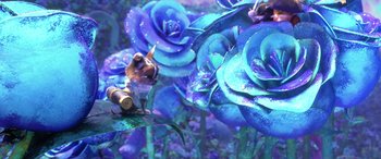 Movie still from “Puss in Boots: The Last Wish” (2022), directed by Januel Mercado – A cat sitting on top of a plant with blue flowers; Wide shot, Low angle