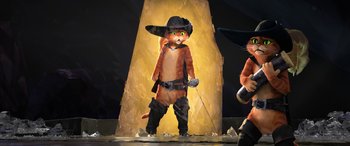 Movie still from “Puss in Boots: The Last Wish” (2022), directed by Januel Mercado – A person dressed up as a cat in a cowboy outfit; Medium shot, Low angle