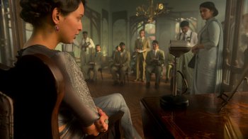 A group of men and women sitting in a dimly - lit room