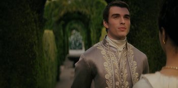 Movie still from “Queen Charlotte: A Bridgerton Story” (2023), directed by Tom Verica – A young man in a gray and white suit; Medium shot, Over the shoulder angle