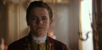 Movie still from “Queen Charlotte: A Bridgerton Story” (2023), directed by Tom Verica – A young man in a red and yellow jacket; Close Up shot, Low angle