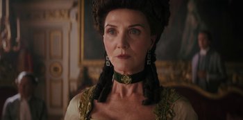 Movie still from “Queen Charlotte: A Bridgerton Story” (2023), directed by Tom Verica – An older woman wearing a green and gold dress; Close Up shot, Low angle