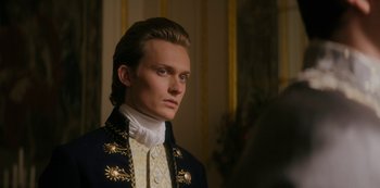 Movie still from “Queen Charlotte: A Bridgerton Story” (2023), directed by Tom Verica – A man in a suit and a white shirt is standing in a room; Close Up shot, Over the shoulder angle