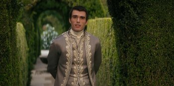 Movie still from “Queen Charlotte: A Bridgerton Story” (2023), directed by Tom Verica – A man in a suit standing in front of a hedge; Medium shot, Over the shoulder angle