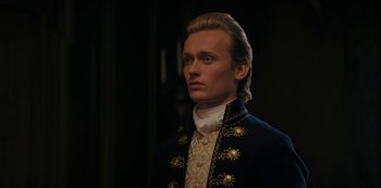 Movie still from “Queen Charlotte: A Bridgerton Story” (2023), directed by Tom Verica – A person wearing a suit and tie; Close Up shot, Low angle
