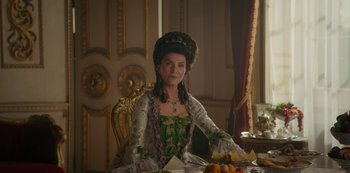 Movie still from “Queen Charlotte: A Bridgerton Story” (2023), directed by Tom Verica – A woman sitting at a dinner table wearing an elaborate dress; Medium shot, Over the shoulder angle