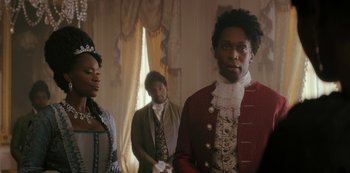 Movie still from “Queen Charlotte: A Bridgerton Story” (2023), directed by Tom Verica – A man and two women standing next to each other in a room; Medium shot, Over the shoulder angle