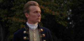 Movie still from “Queen Charlotte: A Bridgerton Story” (2023), directed by Tom Verica – A man in a suit and a white shirt is looking to his left; Close Up shot, Low angle
