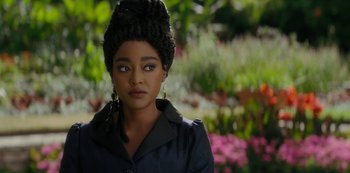 Movie still from “Queen Charlotte: A Bridgerton Story” (2023), directed by Tom Verica – A young woman with a black coat and a black hat; Close Up shot, Over the shoulder angle