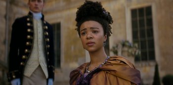 Movie still from “Queen Charlotte: A Bridgerton Story” (2023), directed by Tom Verica – A woman with a very large afro looking at the camera; Close Up shot, Over the shoulder angle