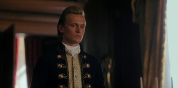 Movie still from “Queen Charlotte: A Bridgerton Story” (2023), directed by Tom Verica – A man in a black jacket standing in front of a wall; Close Up shot, Low angle