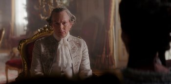 Movie still from “Queen Charlotte: A Bridgerton Story” (2023), directed by Tom Verica – A man in a white suit sitting in front of a mirror; Close Up shot, Over the shoulder angle
