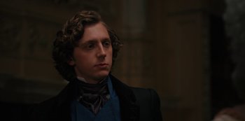 Movie still from “Queen Charlotte: A Bridgerton Story” (2023), directed by Tom Verica – A young man in a suit and a tie; Close Up shot, Over the shoulder angle