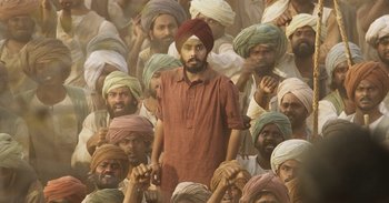 A group of men wearing turbans with a man standing in front of them